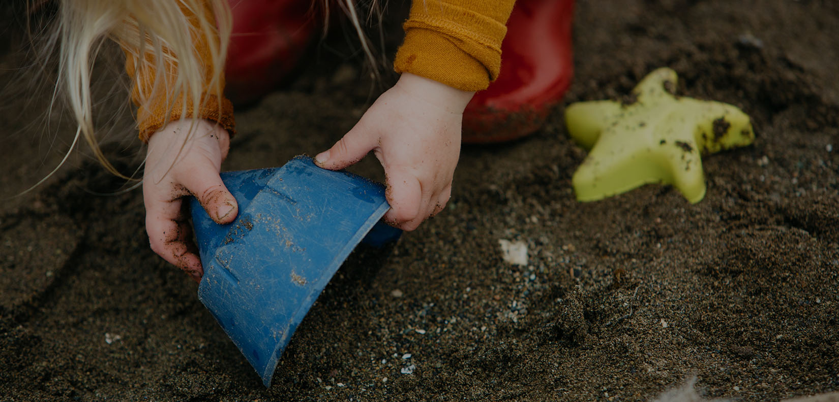 child with sand and bucket